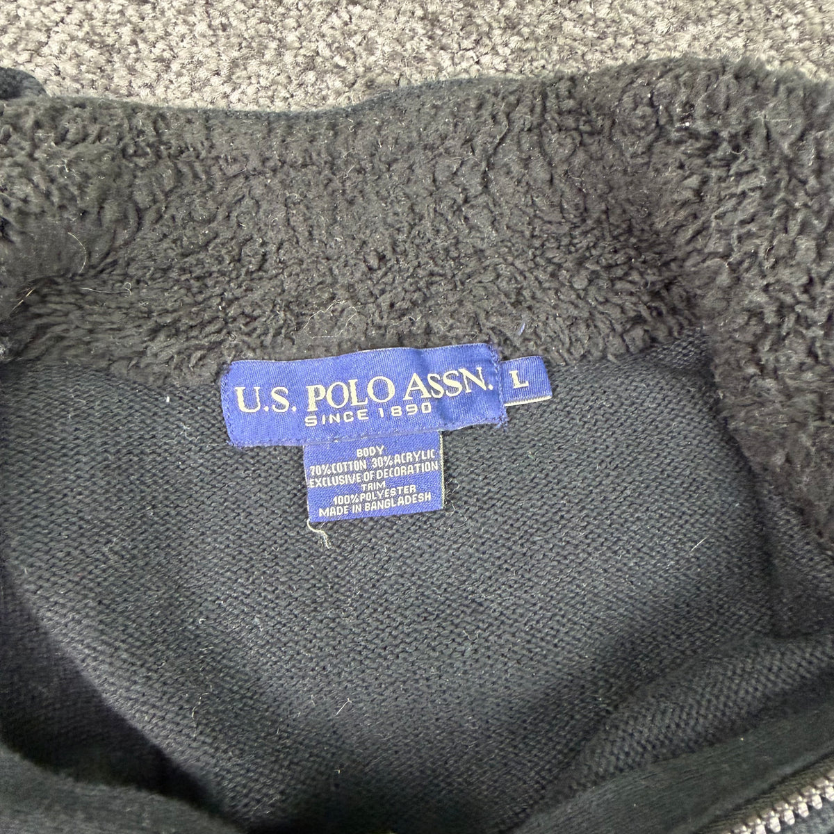 Back of the charcoal striped U.S. Polo Assn. quarter-zip sweater